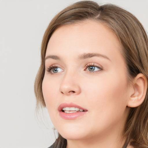 Joyful white young-adult female with long  brown hair and blue eyes