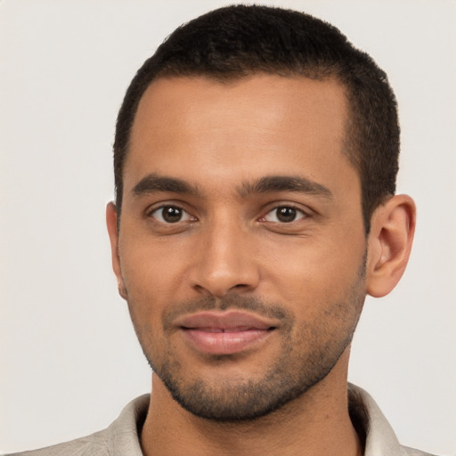 Joyful black young-adult male with short  brown hair and brown eyes