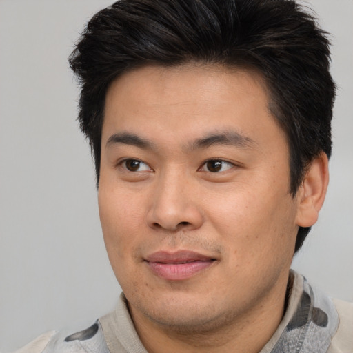 Joyful asian adult male with short  brown hair and brown eyes