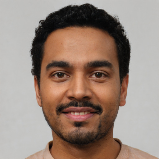 Joyful latino young-adult male with short  black hair and brown eyes