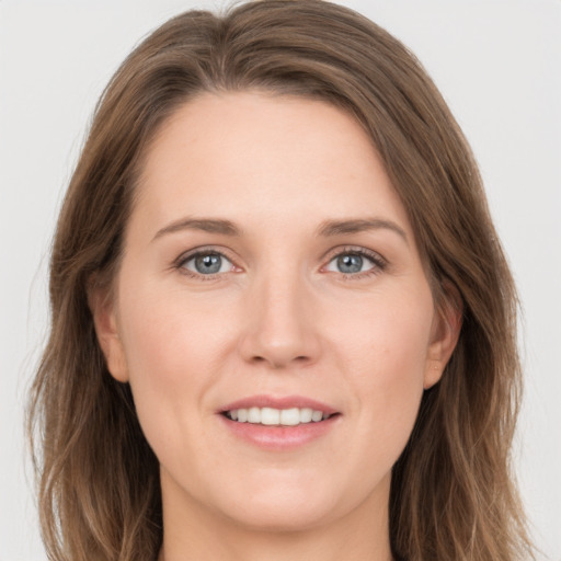 Joyful white young-adult female with long  brown hair and grey eyes