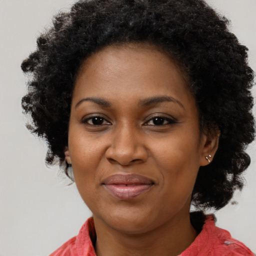 Joyful black adult female with long  black hair and brown eyes