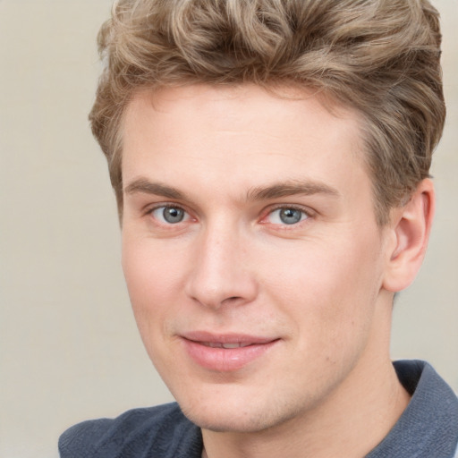 Joyful white young-adult male with short  brown hair and blue eyes