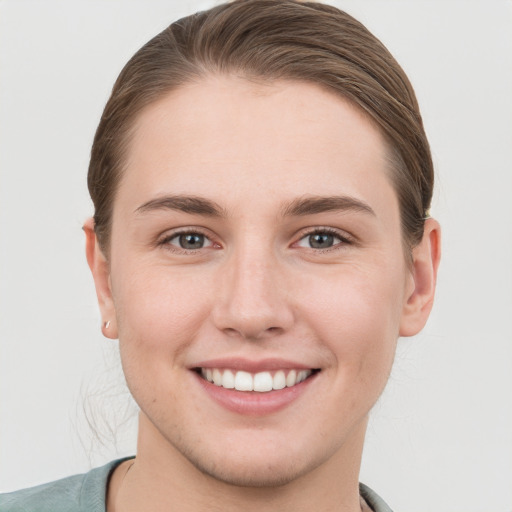 Joyful white young-adult female with short  brown hair and grey eyes