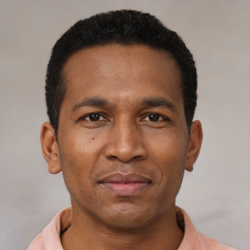 Joyful latino young-adult male with short  brown hair and brown eyes