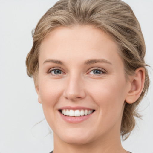 Joyful white young-adult female with medium  brown hair and blue eyes