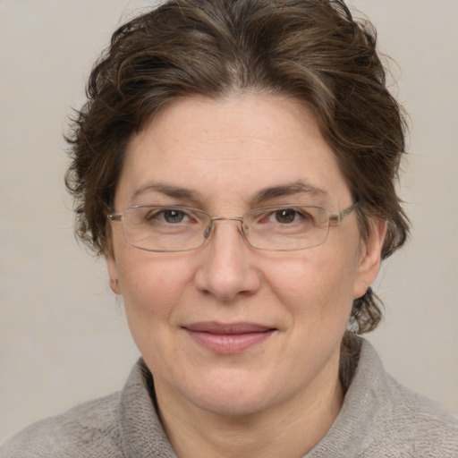 Joyful white adult female with medium  brown hair and blue eyes