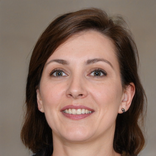 Joyful white adult female with medium  brown hair and grey eyes