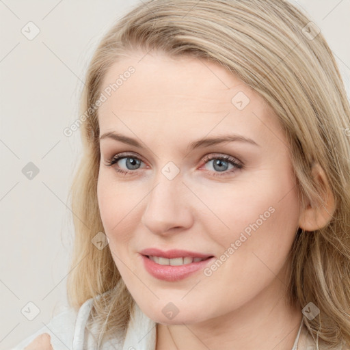 Joyful white young-adult female with long  brown hair and blue eyes