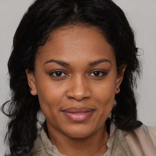 Joyful black young-adult female with long  brown hair and brown eyes