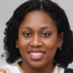 Joyful black adult female with long  brown hair and brown eyes