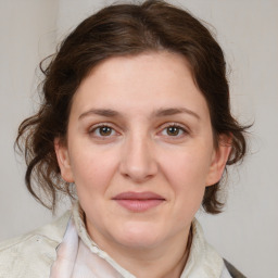 Joyful white young-adult female with medium  brown hair and grey eyes