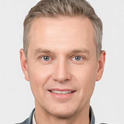 Joyful white adult male with short  brown hair and grey eyes