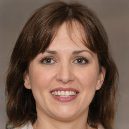 Joyful white adult female with medium  brown hair and grey eyes