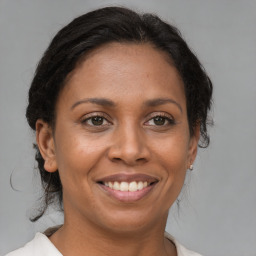 Joyful black adult female with medium  brown hair and brown eyes