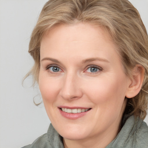 Joyful white adult female with medium  brown hair and blue eyes