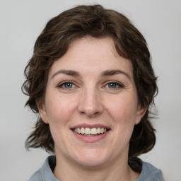 Joyful white adult female with medium  brown hair and grey eyes