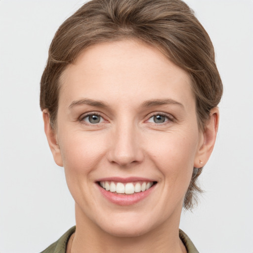 Joyful white young-adult female with short  brown hair and grey eyes