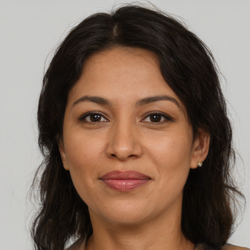 Joyful latino adult female with long  brown hair and brown eyes