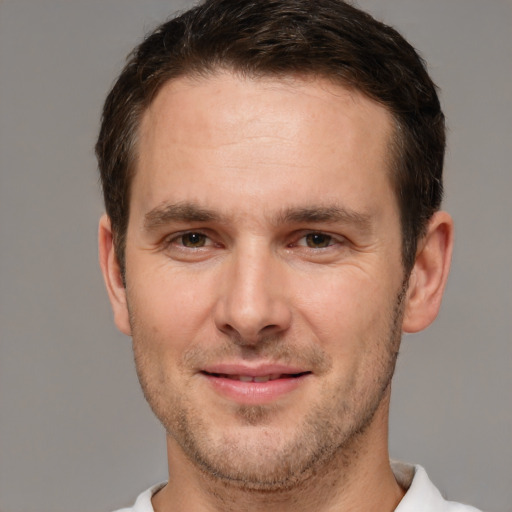 Joyful white young-adult male with short  brown hair and brown eyes