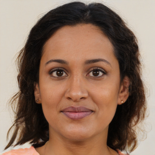 Joyful latino young-adult female with medium  brown hair and brown eyes