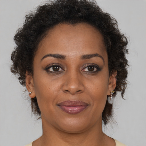 Joyful black adult female with short  brown hair and brown eyes