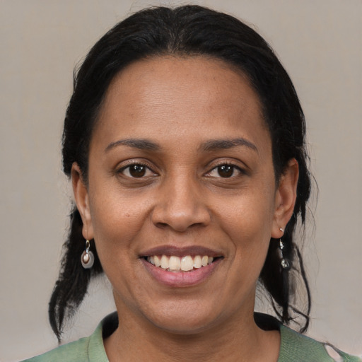 Joyful black adult female with medium  black hair and brown eyes
