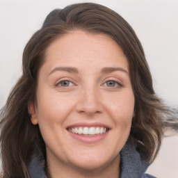 Joyful white adult female with medium  brown hair and grey eyes