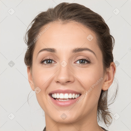 Joyful white young-adult female with medium  brown hair and grey eyes