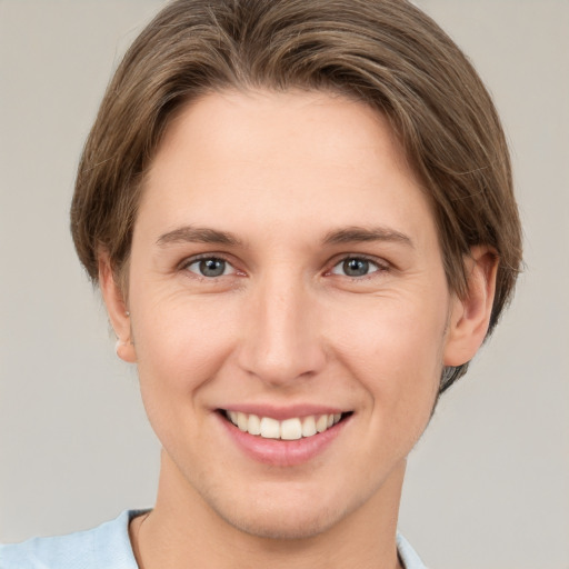 Joyful white young-adult female with short  brown hair and grey eyes