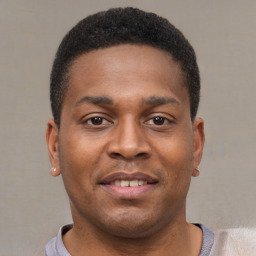 Joyful black young-adult male with short  brown hair and brown eyes