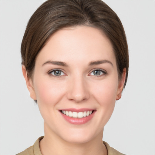 Joyful white young-adult female with short  brown hair and grey eyes