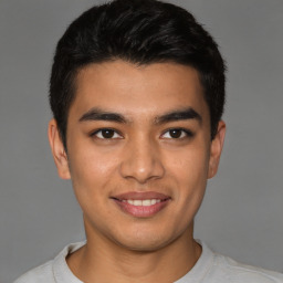 Joyful latino young-adult male with short  brown hair and brown eyes