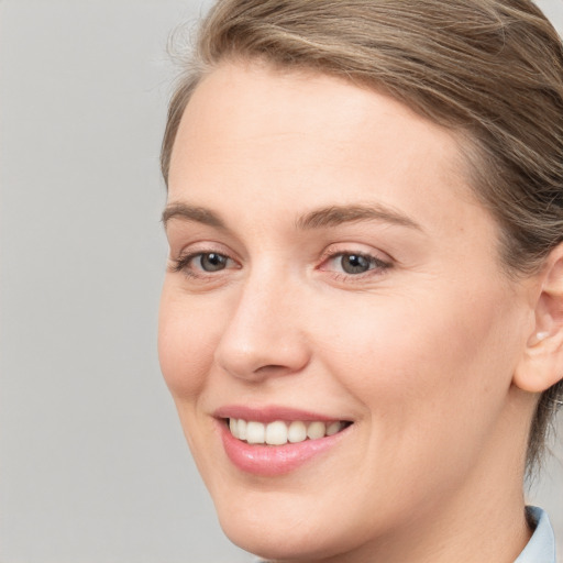 Joyful white young-adult female with medium  brown hair and blue eyes