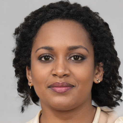 Joyful black young-adult female with long  black hair and brown eyes