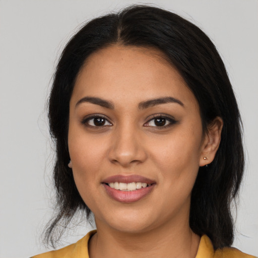 Joyful latino young-adult female with long  brown hair and brown eyes