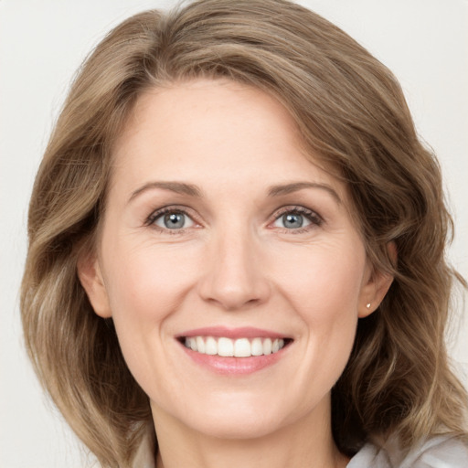 Joyful white adult female with medium  brown hair and green eyes