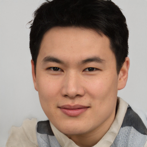 Joyful asian young-adult male with short  brown hair and brown eyes