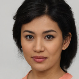 Joyful latino young-adult female with medium  brown hair and brown eyes