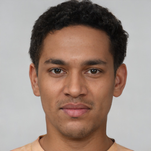Joyful latino young-adult male with short  brown hair and brown eyes