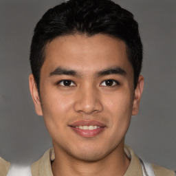 Joyful latino young-adult male with short  brown hair and brown eyes