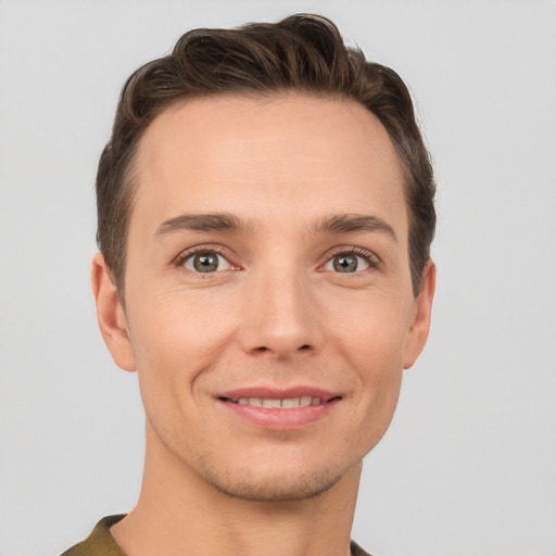 Joyful white young-adult male with short  brown hair and grey eyes