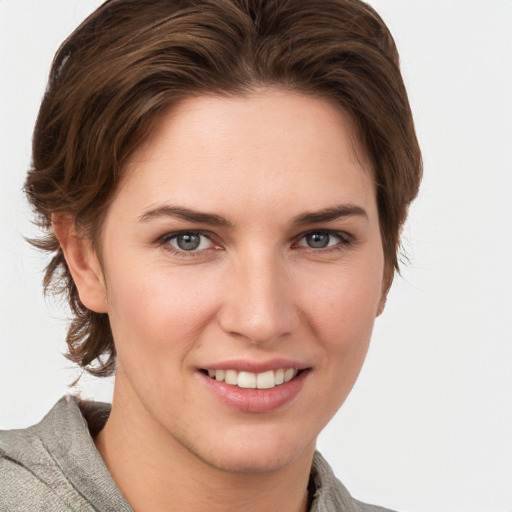 Joyful white young-adult female with medium  brown hair and grey eyes