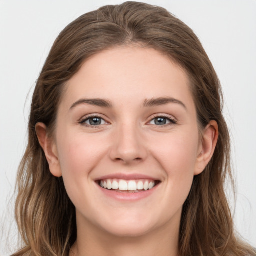 Joyful white young-adult female with long  brown hair and grey eyes