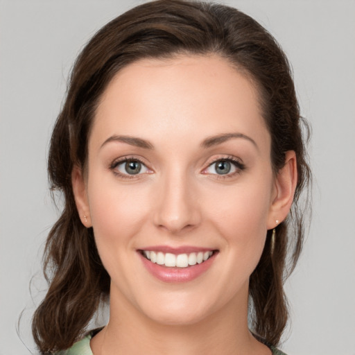 Joyful white young-adult female with medium  brown hair and green eyes