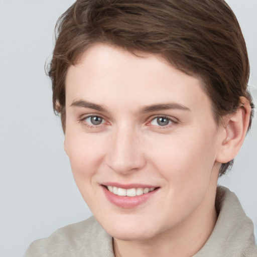 Joyful white young-adult female with short  brown hair and grey eyes