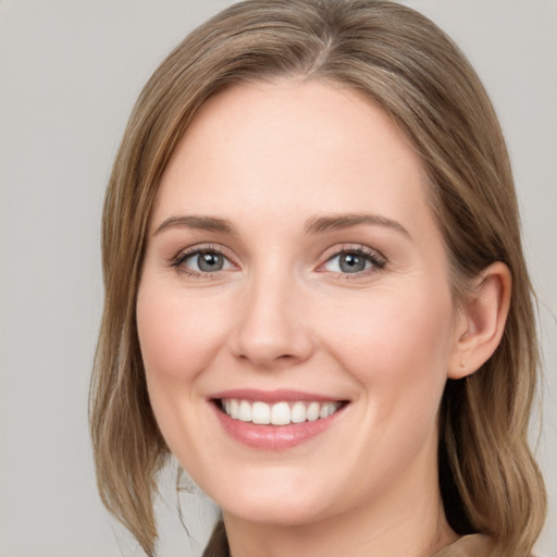 Joyful white young-adult female with medium  brown hair and blue eyes