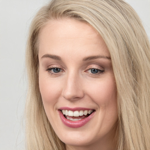 Joyful white young-adult female with long  brown hair and blue eyes