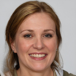 Joyful white adult female with medium  brown hair and blue eyes