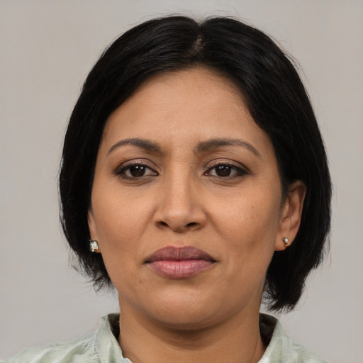 Joyful latino adult female with medium  black hair and brown eyes